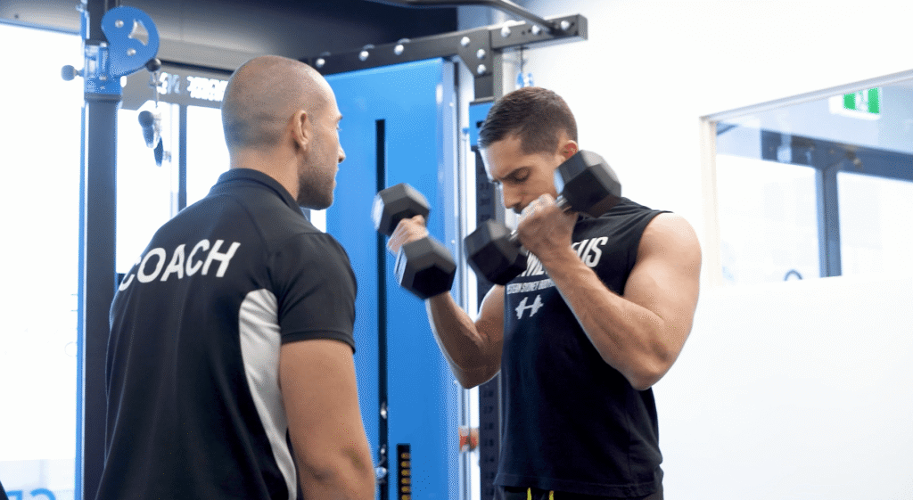 Trainer with client lifting dumbells
